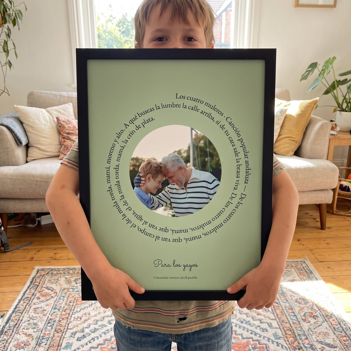 Niño sosteniendo el cuadro personalizado verde con la letra de la canción y la foto de sus abuelos