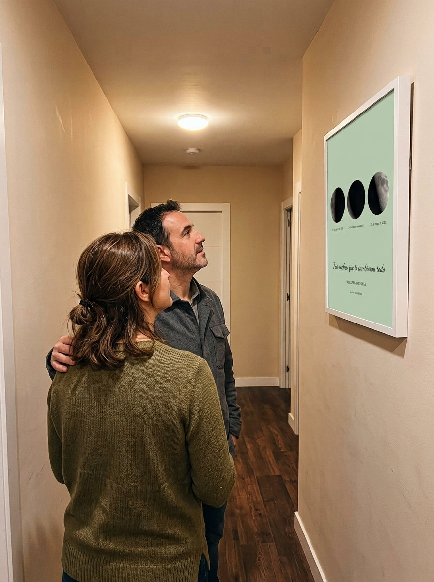 Una pareja mirando el cuadro fase lunar personalizado de aniversario recién colgado