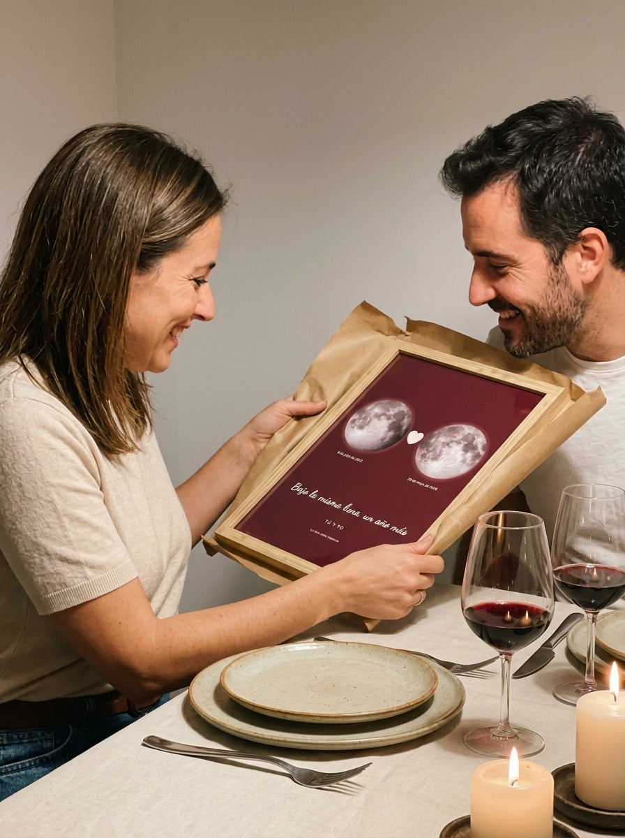 Abriendo el regalo del cuadro fase lunar personalizado de aniversario en una comida familiar
