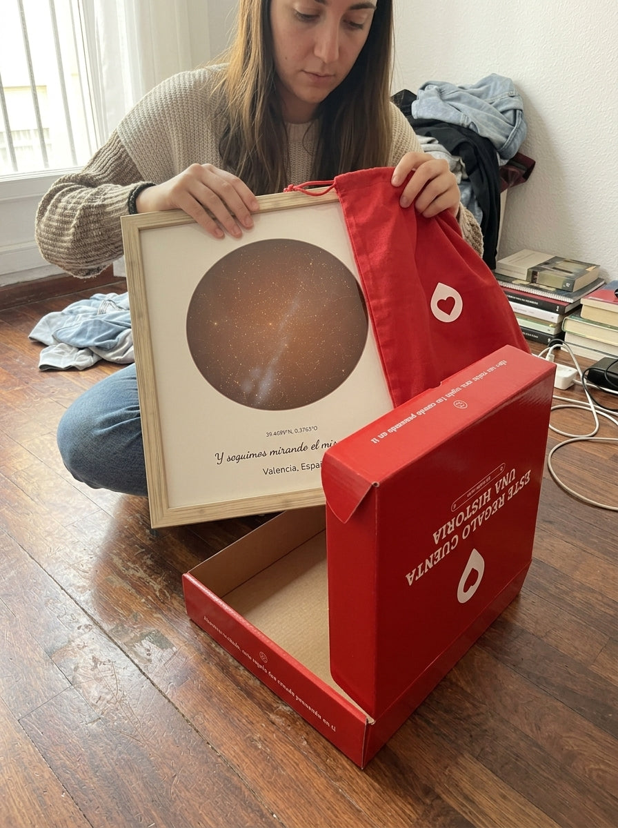 Sacando el cuadro mapa estelar personalizado de aniversario de la bolsa de regalo, con la caja abierta al lado