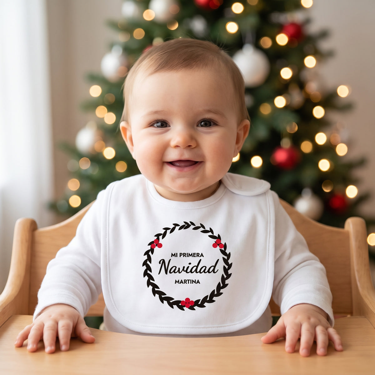 Bebé con babero «Mi Primera Navidad» con corona de hojas y su nombre