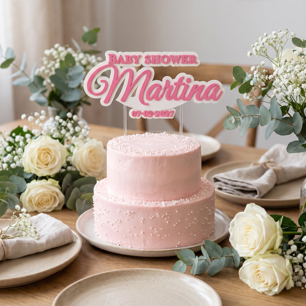 Mesa de celebración con la tarta y el cake topper de baby shower personalizado