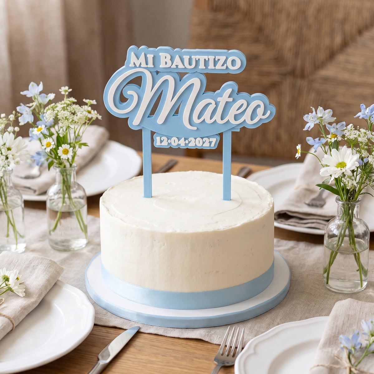 Mesa de celebración con la tarta y el cake topper de bautizo personalizado