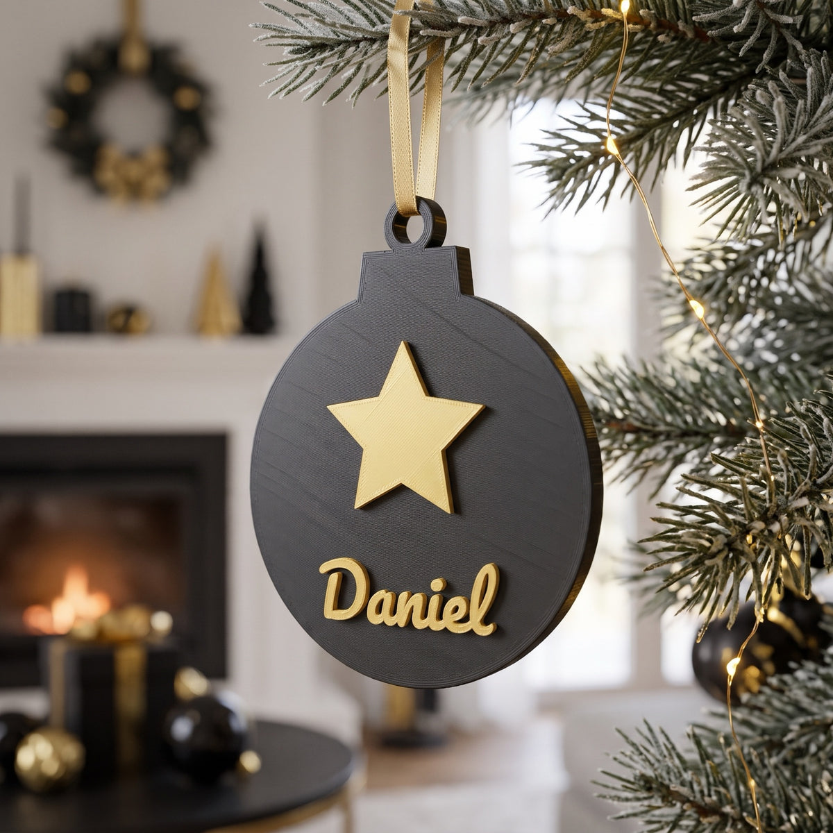 Bola de Navidad negra y dorada con estrella y el nombre Daniel junto a la chimenea