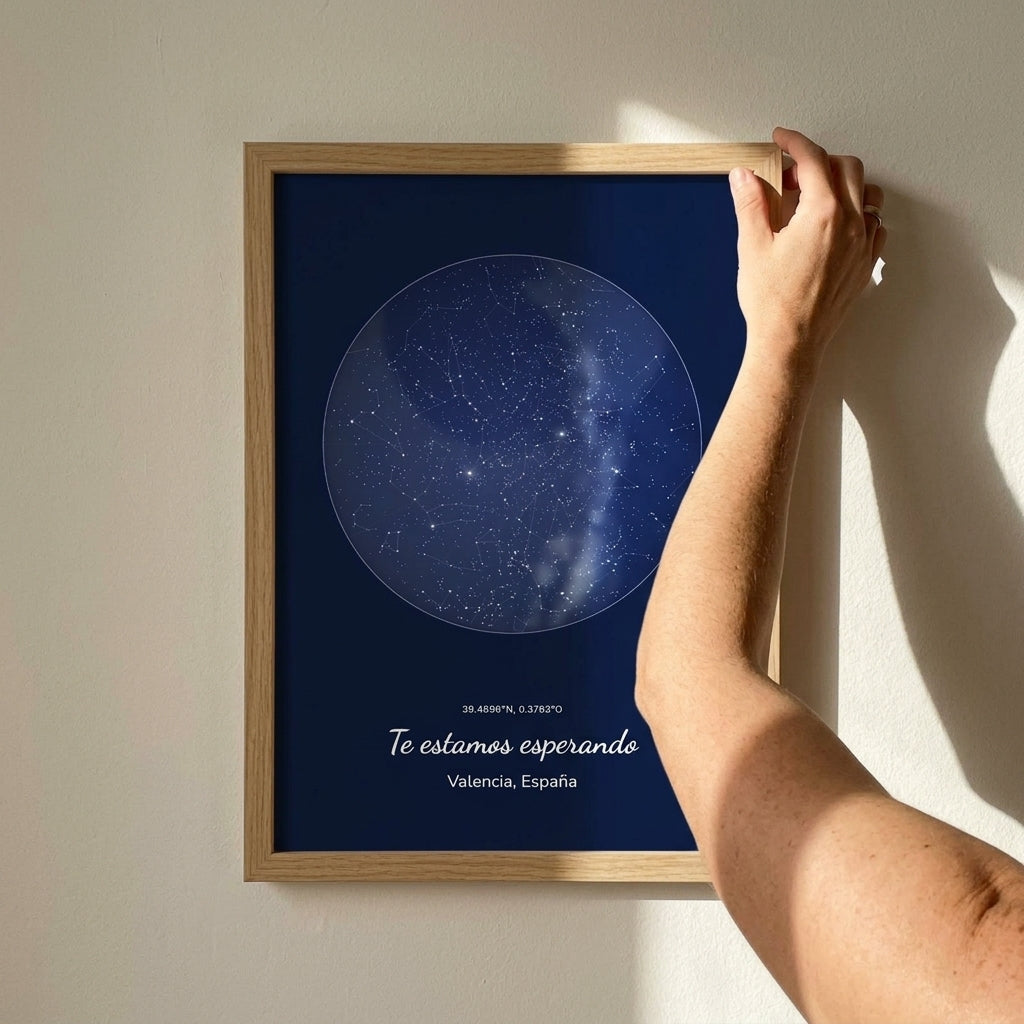 Enderezando el cuadro mapa estelar personalizado de baby shower recién colgado en la pared