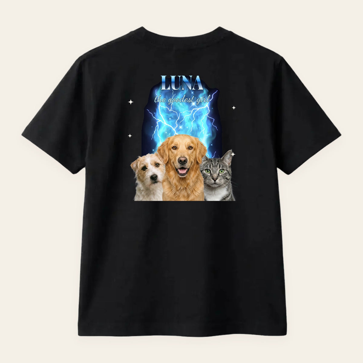 Camiseta negra personalizada estilo vintage de rap de los 90 con tres mascotas —un terrier, una golden retriever y un gato— sobre humo y rayos azules, el título LUNA en cromado y «the goodest girl», estampada en la espalda