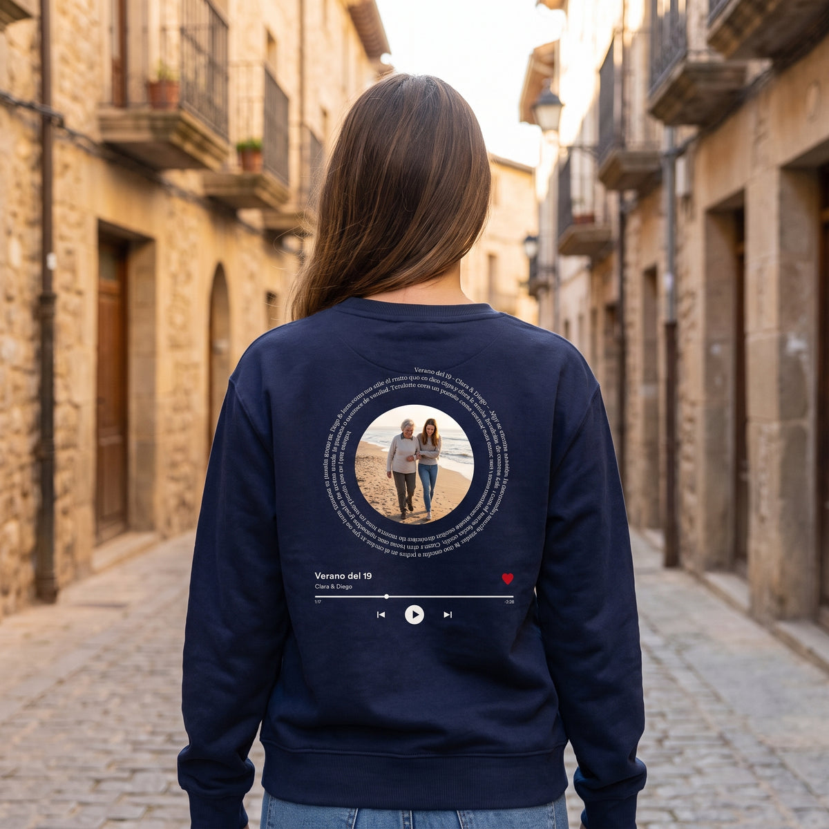 Mujer de espaldas con la sudadera azul marino personalizada con su foto, la letra de su canción en espiral y el reproductor estampado en la espalda