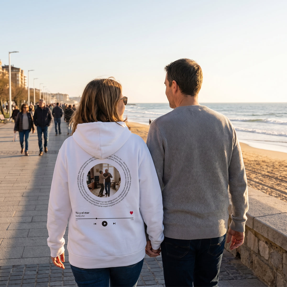 Paseo al atardecer con la sudadera con capucha blanca personalizada con su foto, la letra de su canción en espiral y el reproductor estampado en la espalda