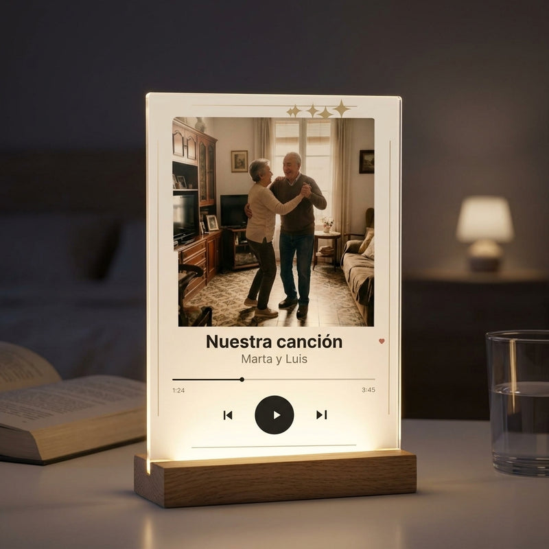 Placa de metacrilato personalizada con vuestra canción encendida sobre la base de madera con luz LED, en una mesilla de noche