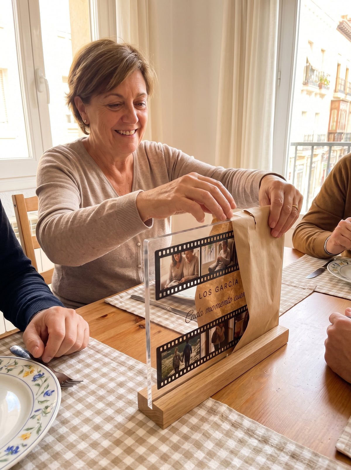 Abriendo el regalo de la placa de metacrilato personalizada carrete de fotos en una comida familiar