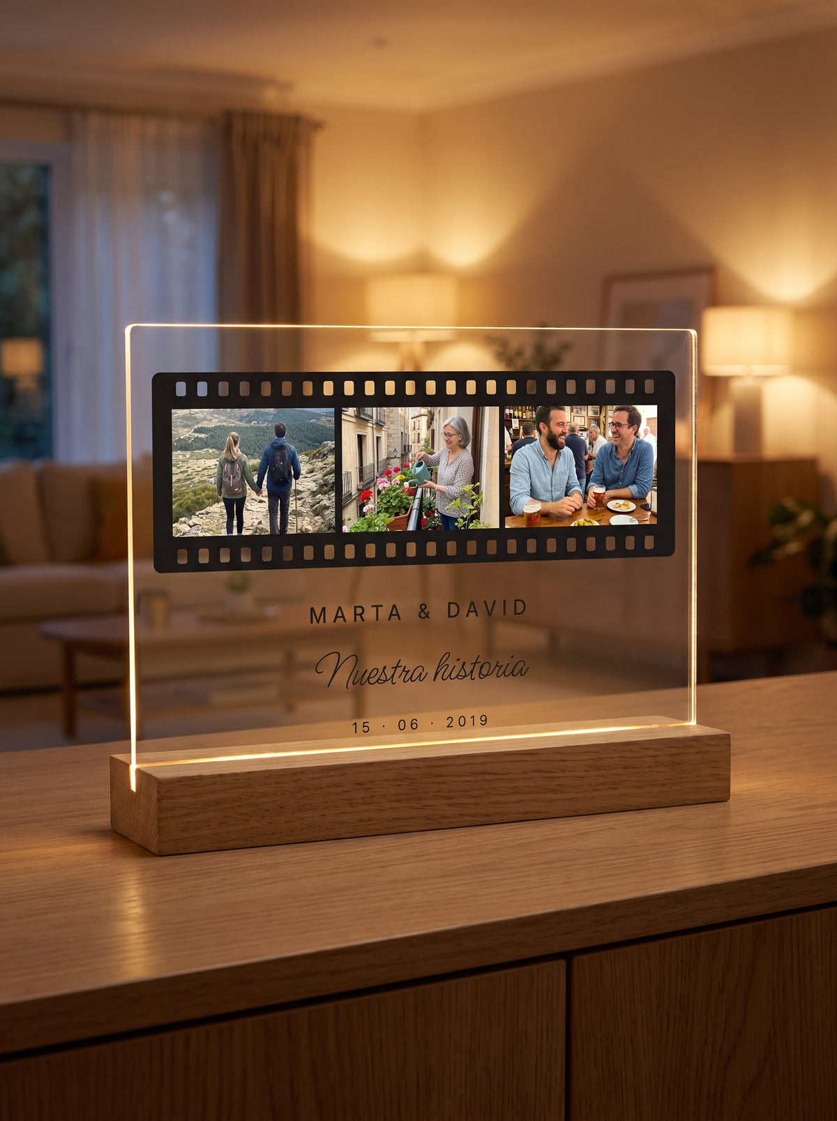 Placa de metacrilato personalizada carrete de fotos encendida sobre su base de roble con luz LED, en un salón al atardecer