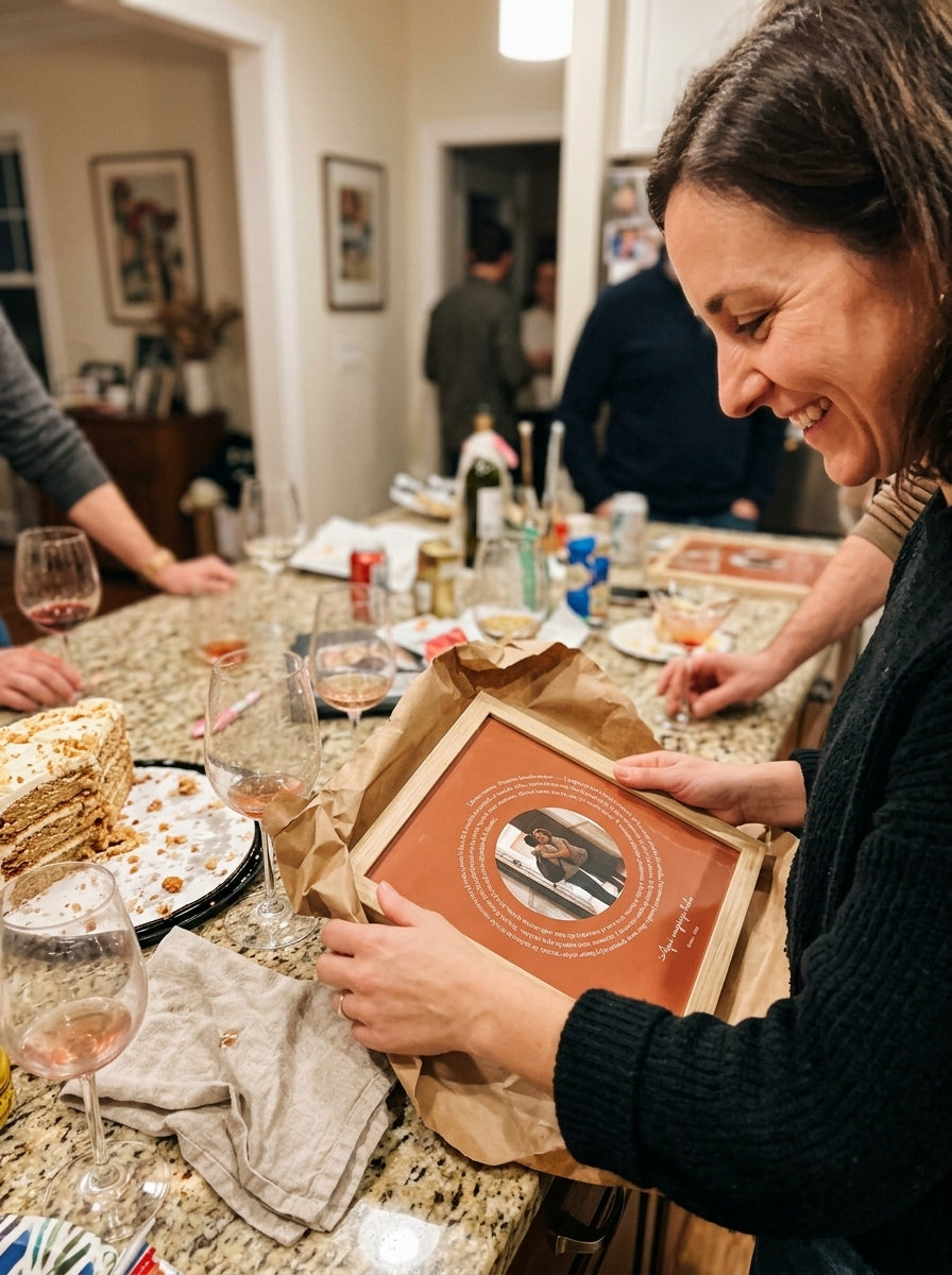 Abriendo el regalo del cuadro canción personalizado de casa nueva en una comida familiar