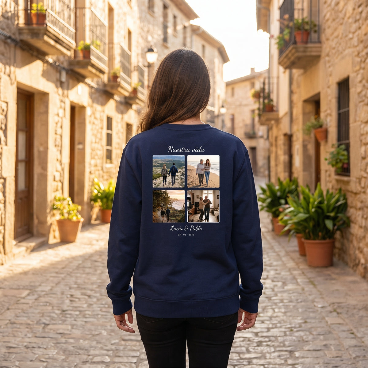 Mujer de espaldas con la sudadera azul marino personalizada con un collage de cuatro fotos, «Nuestra vida» y los nombres Lucía & Pablo estampado en la espalda