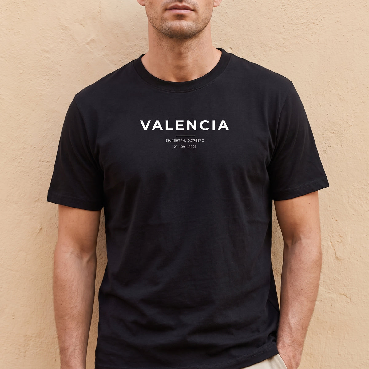 Hombre con la camiseta negra personalizada con Valencia y sus coordenadas estampado en el pecho
