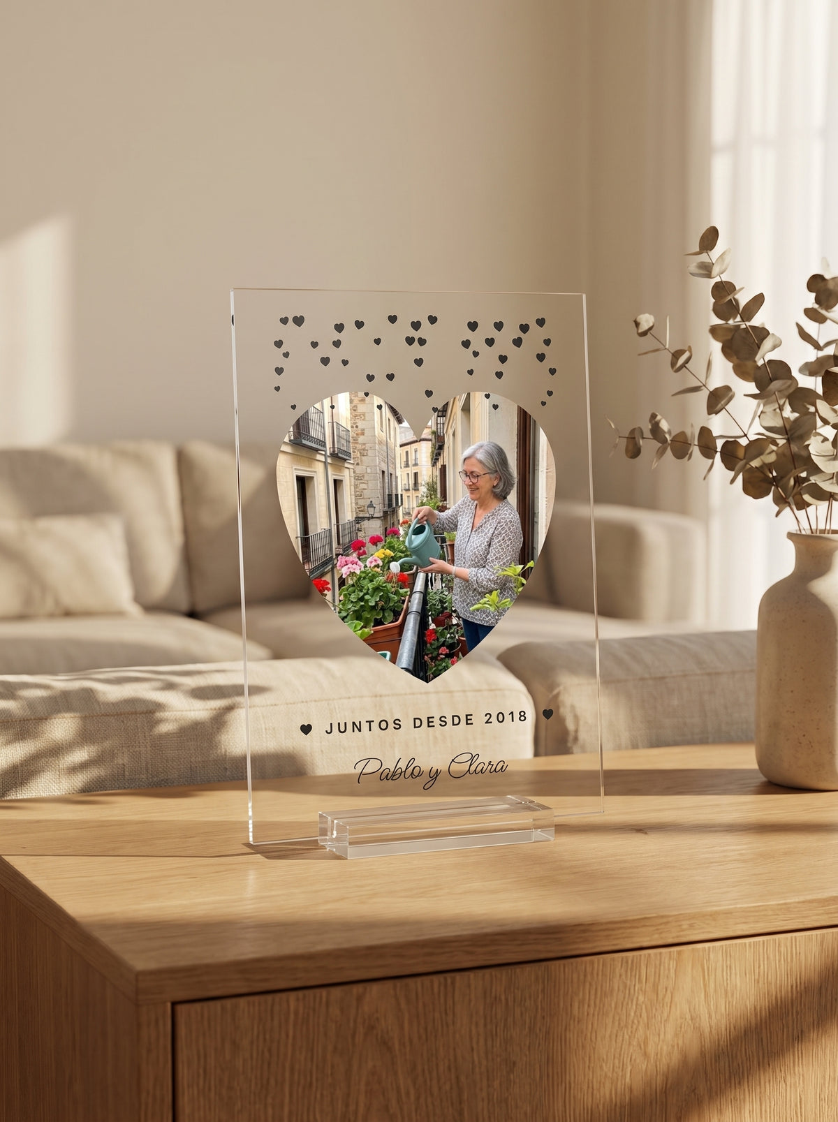 Placa de metacrilato personalizada con corazoncitos sobre el aparador de un salón, con la luz de la tarde entrando por la derecha