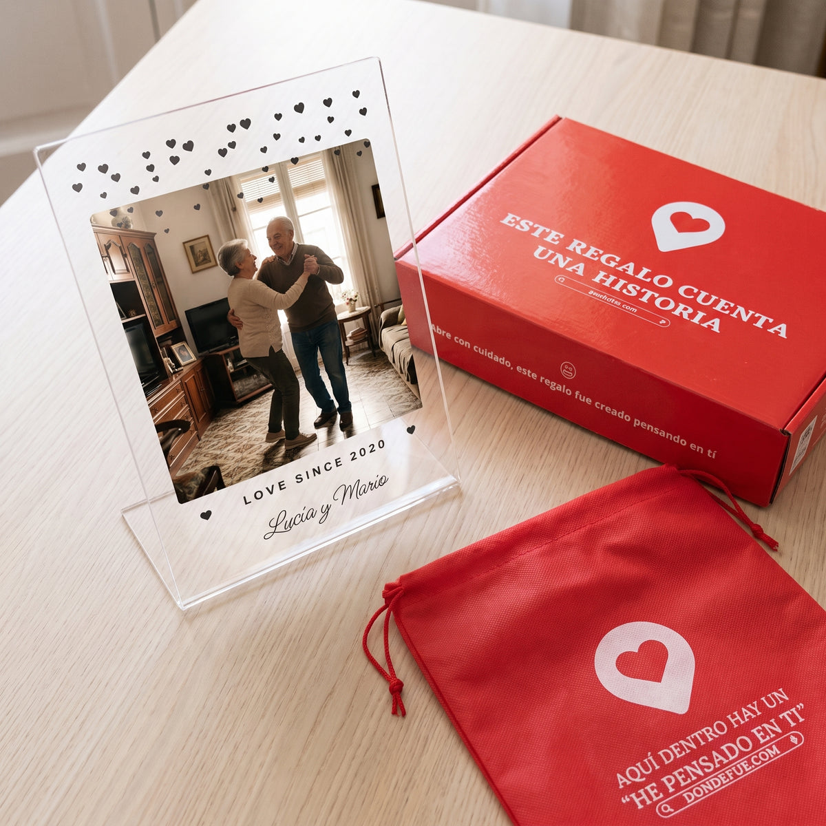 Placa de metacrilato personalizada con corazoncitos junto a la caja y la bolsa de regalo de Donde Fue