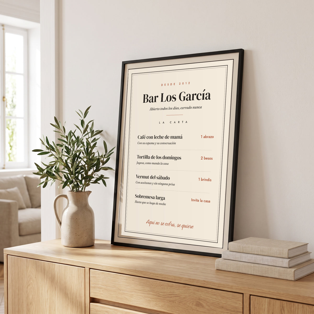Cuadro «La carta de casa» personalizado, la carta del Bar Los García, con marco negro en el aparador del salón
