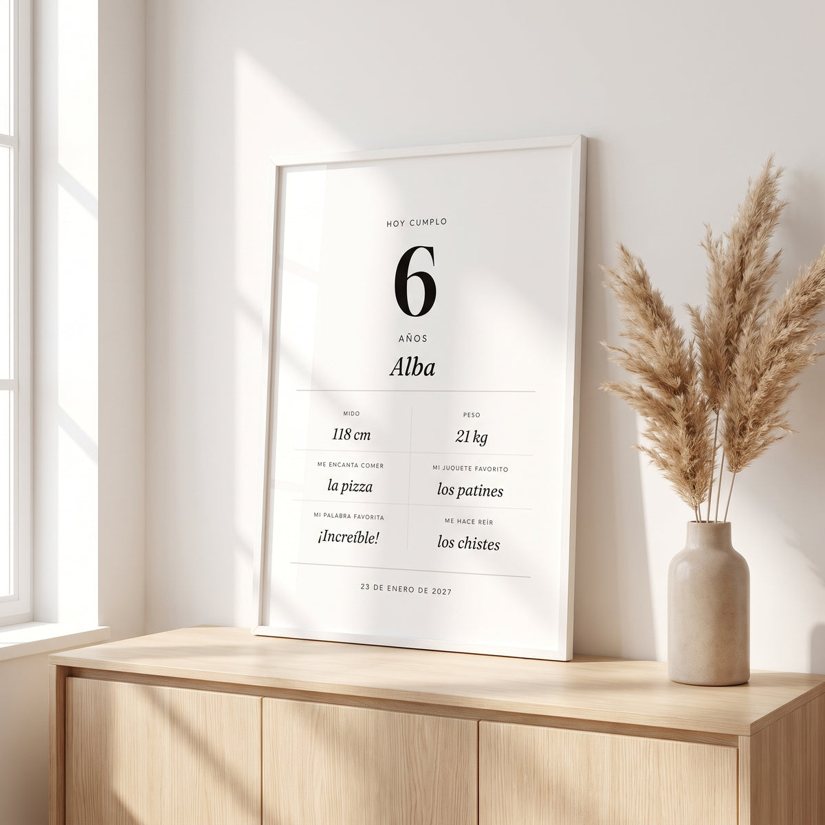 Cuadro de cumpleaños personalizado en marco blanco sobre un mueble de madera
