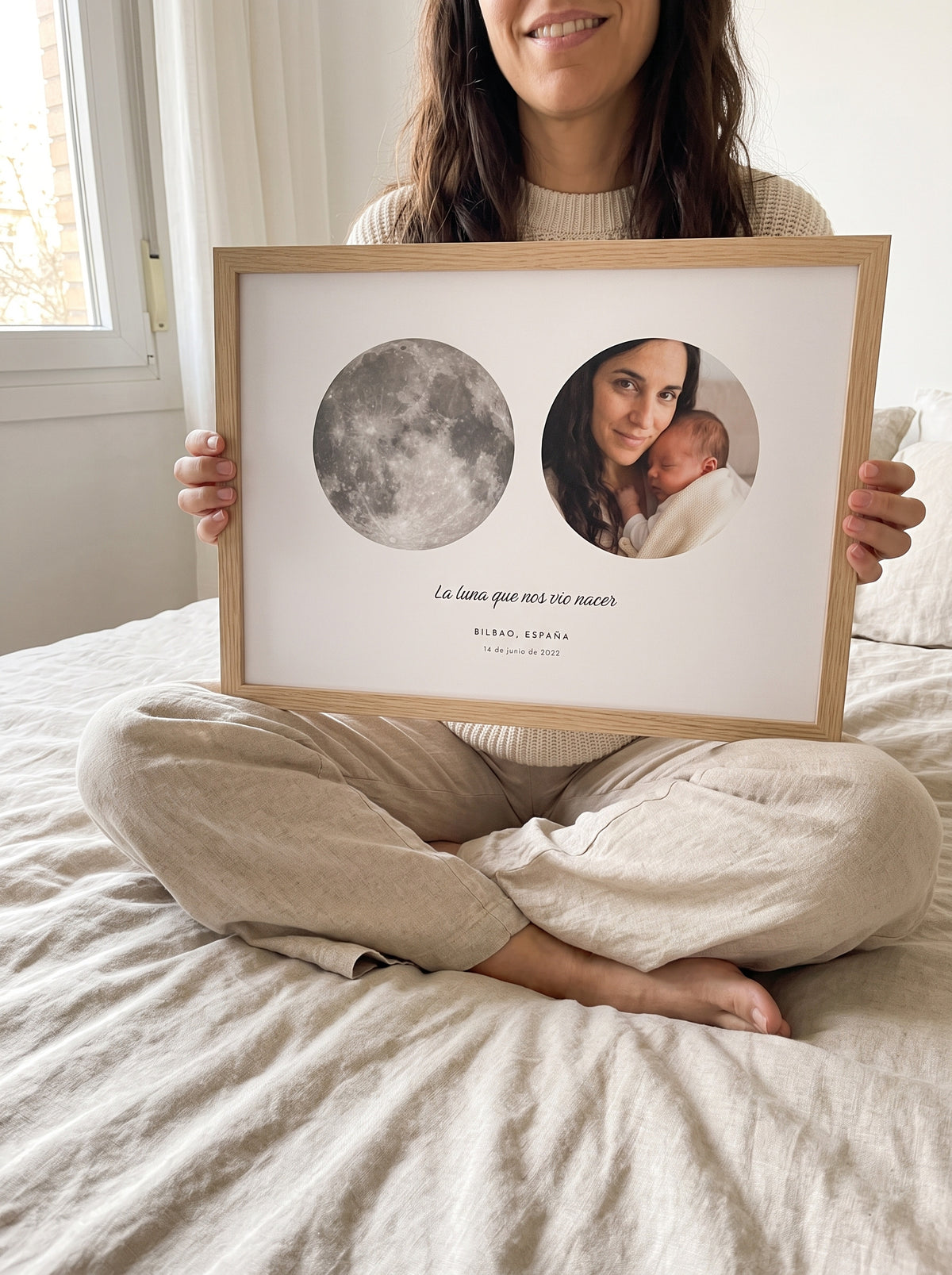 Cuadro La luna del día que fuiste mamá personalizado (La luna que nos vio nacer · BILBAO, ESPAÑA) sostenido entre las manos, con marco de madera
