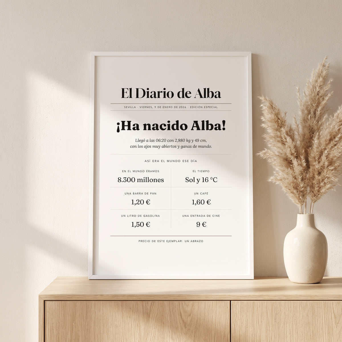 Cuadro «El día que naciste» con portada de periódico con marco blanco en el aparador del salón, con luz de día