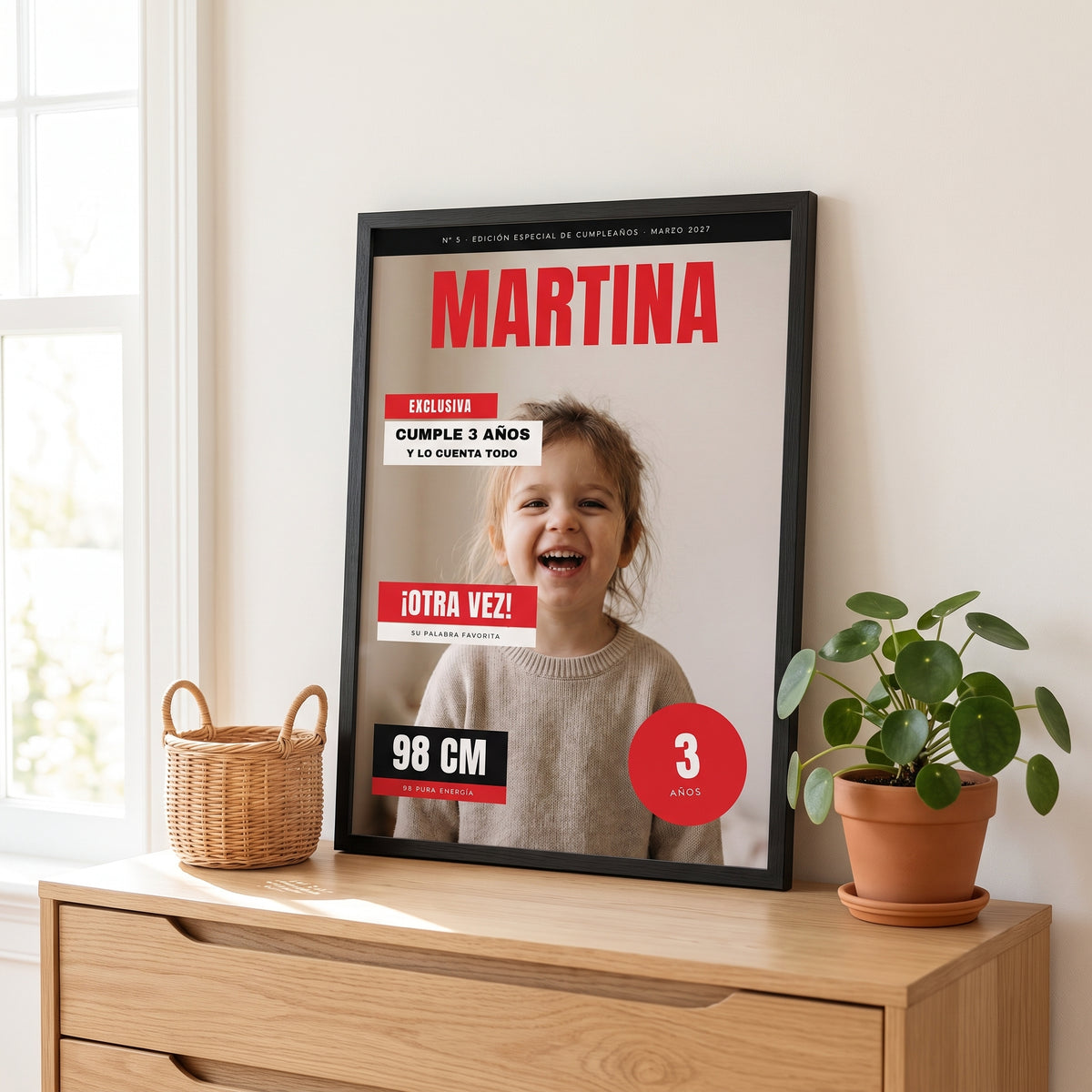 Cuadro portada de revista con la foto del niño, su nombre y los titulares de su aniversário en marco negro