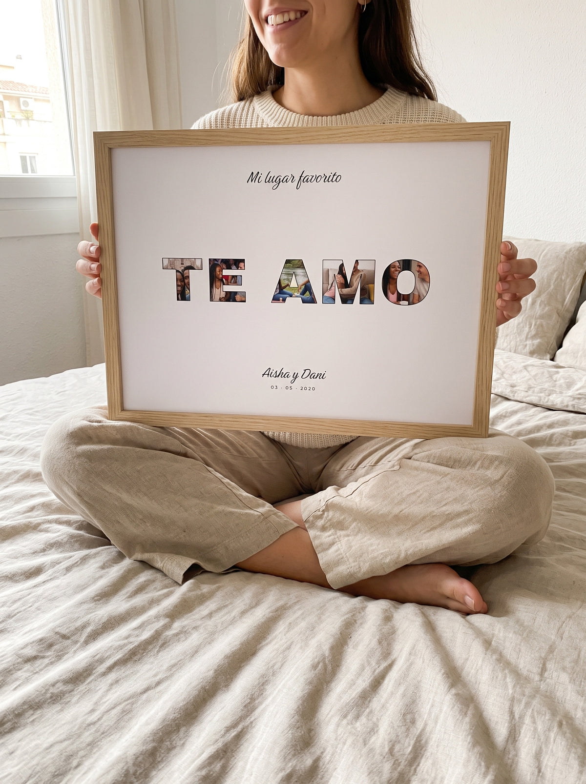 Cuadro TE AMO personalizado (Mi lugar favorito · Aisha y Dani · 03 · 05 · 2020) sostenido entre las manos, con marco de madera