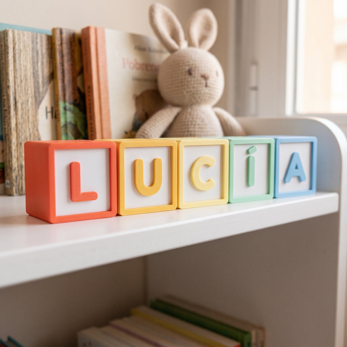 Cubos de letras en relieve 3D con el nombre Lucía en una estantería infantil