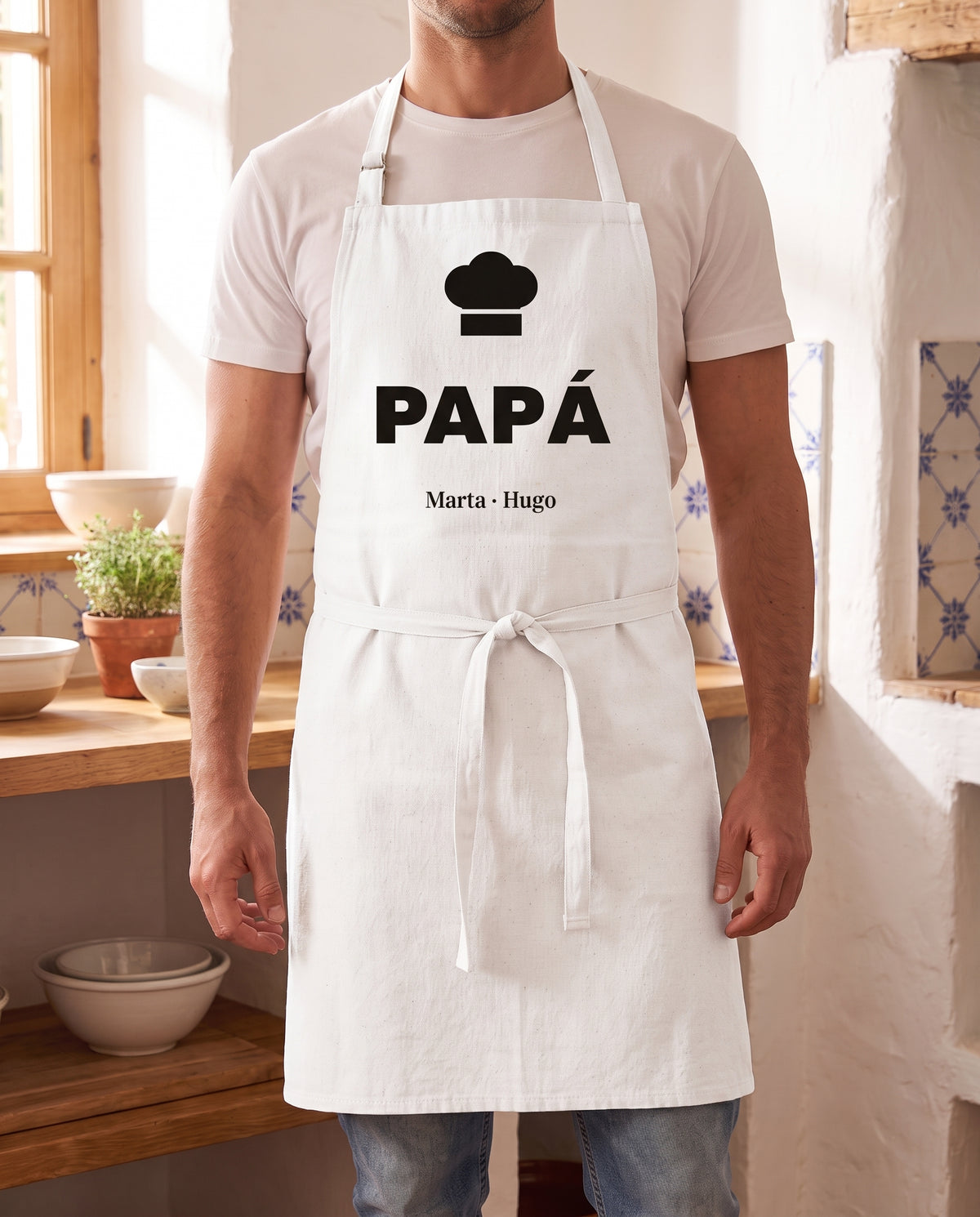 Hombre con un delantal personalizado con gorro de chef, el nombre PAPÁ y los nombres Marta y Hugo
