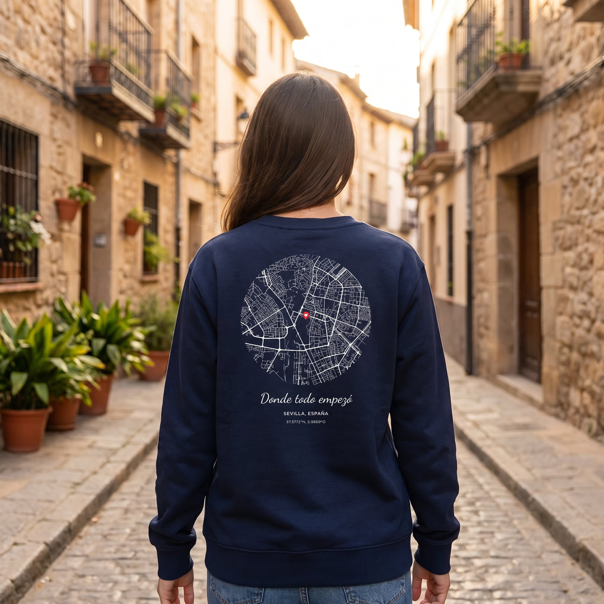 Mujer de espaldas con la sudadera azul marino personalizada con el mapa de Sevilla y «Donde todo empezó» estampado en la espalda