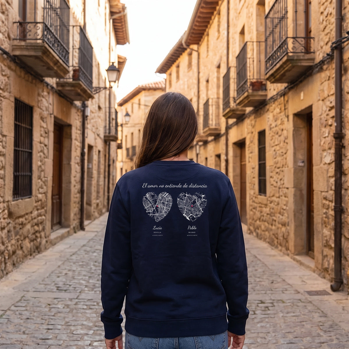 Mujer de espaldas con la sudadera azul marino personalizada con los mapas en corazón de Sevilla y Bilbao estampado en la espalda