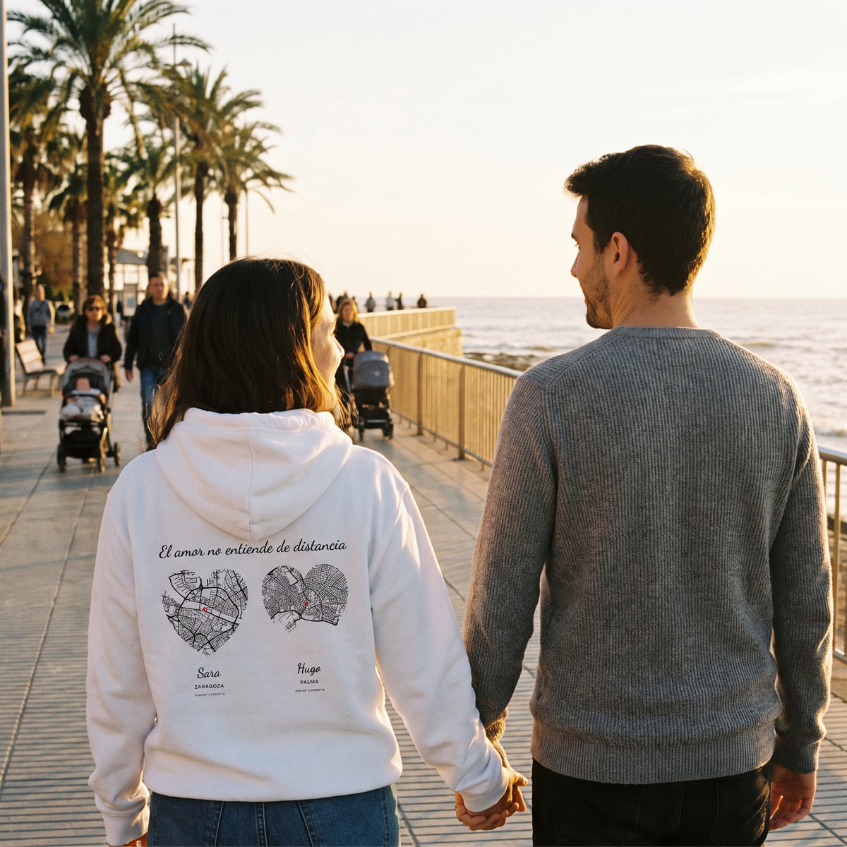 Paseo al atardecer con la sudadera con capucha blanca personalizada con los mapas en corazón de Zaragoza y Palma estampado en la espalda