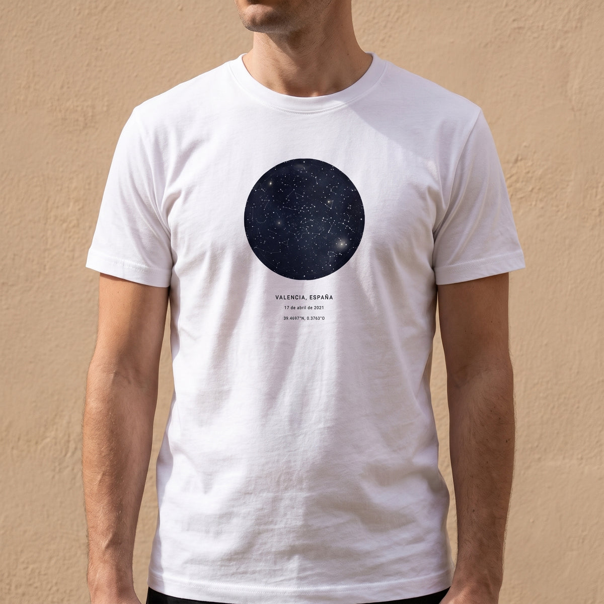 Hombre con la camiseta blanca personalizada con el mapa estelar del cielo de Valencia estampado en el pecho