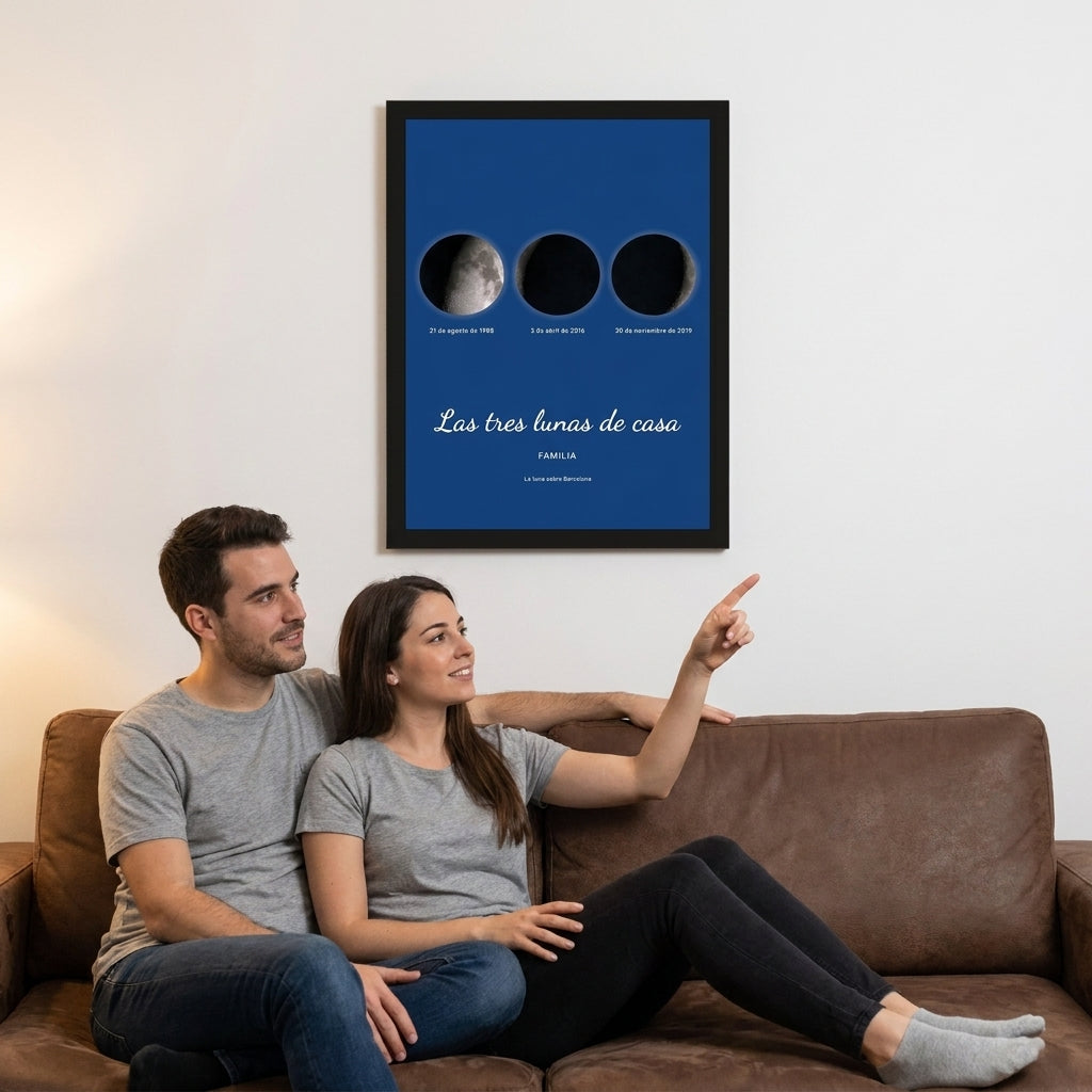 Pareja en el sofá mirando su cuadro de tres lunas con marco negro