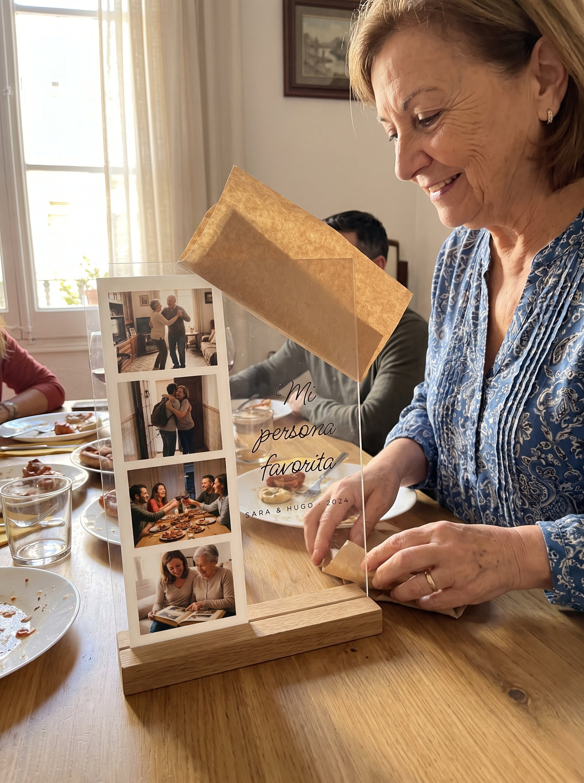 Abriendo el regalo de la placa de metacrilato personalizada fotomatón en una comida familiar