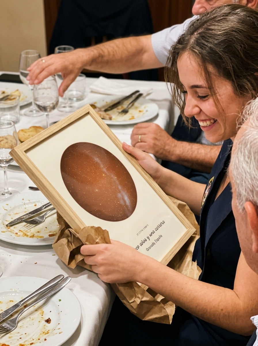 Abriendo el regalo del cuadro mapa estelar personalizado de graduación en una comida familiar
