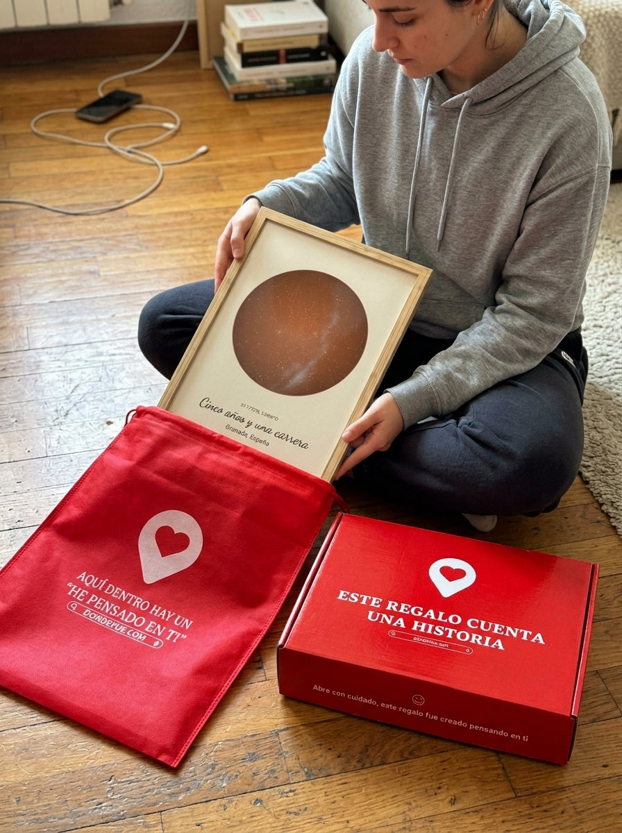 Sacando el cuadro mapa estelar personalizado de graduación de la bolsa de regalo, con la caja abierta al lado