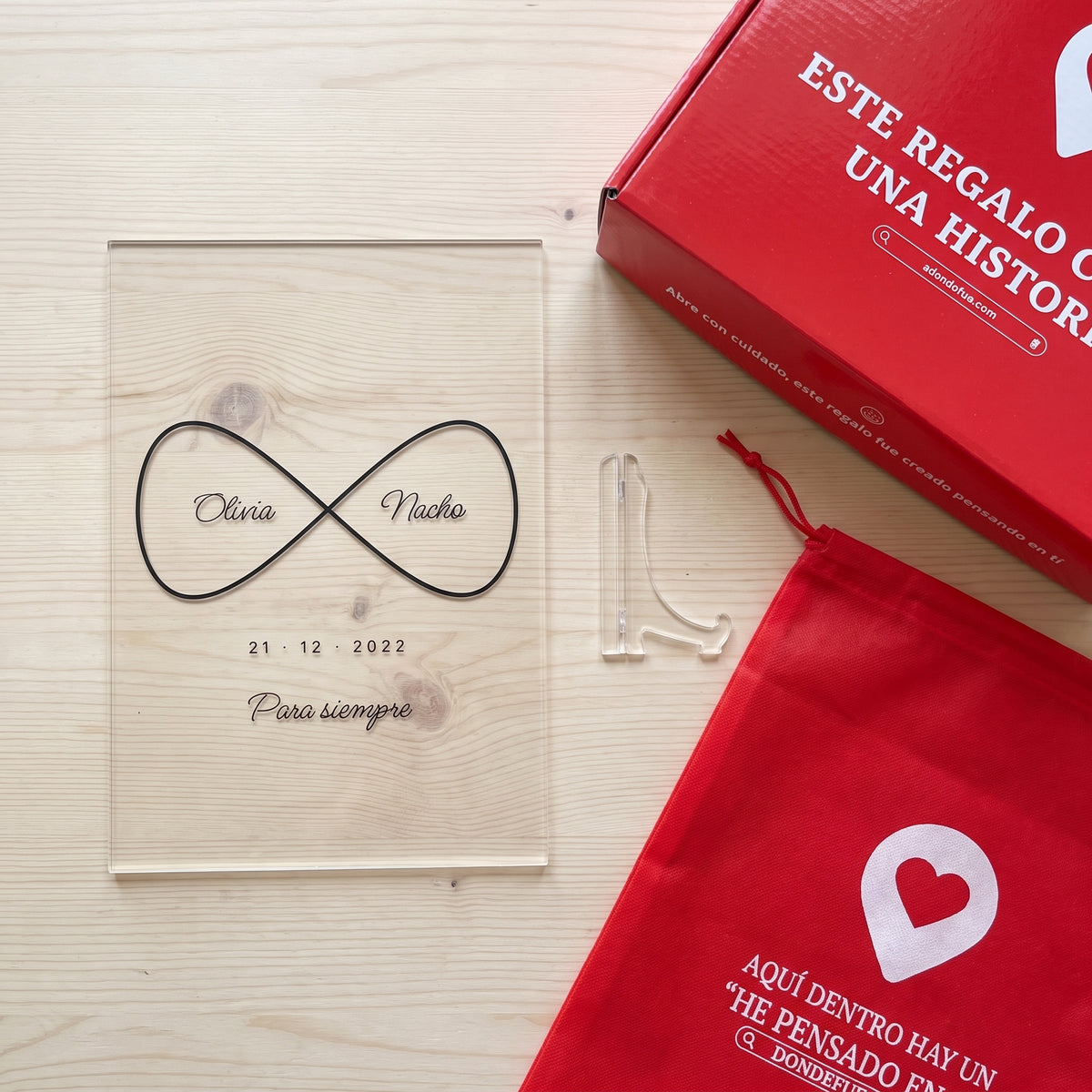 Placa de metacrilato personalizada infinito con nombres junto a la caja y la bolsa de regalo de Donde Fue