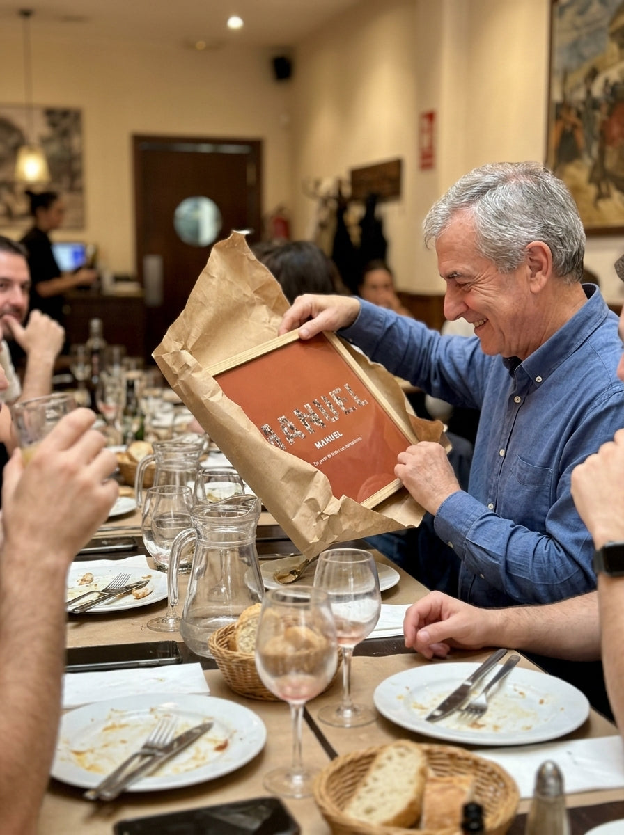 Abriendo el regalo del cuadro nombre con fotos personalizado de jubilación en una comida familiar