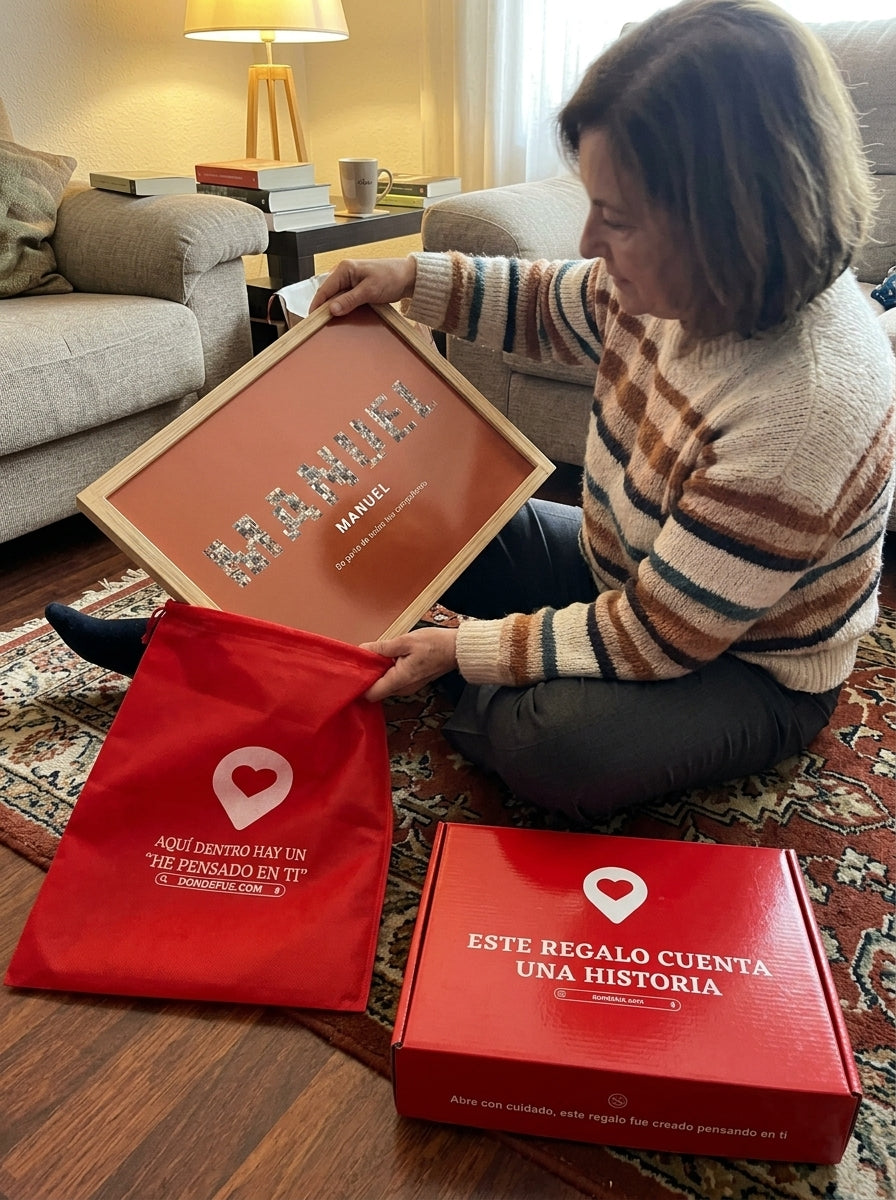 Sacando el cuadro nombre con fotos personalizado de jubilación de la bolsa de regalo, con la caja abierta al lado