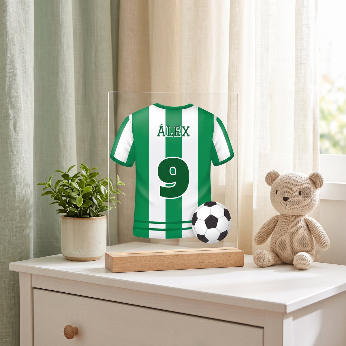 Lámpara infantil personalizada con camiseta de fútbol con camiseta verdiblanca con el nombre Álex y el 9, sobre una cómoda en un dormitorio infantil