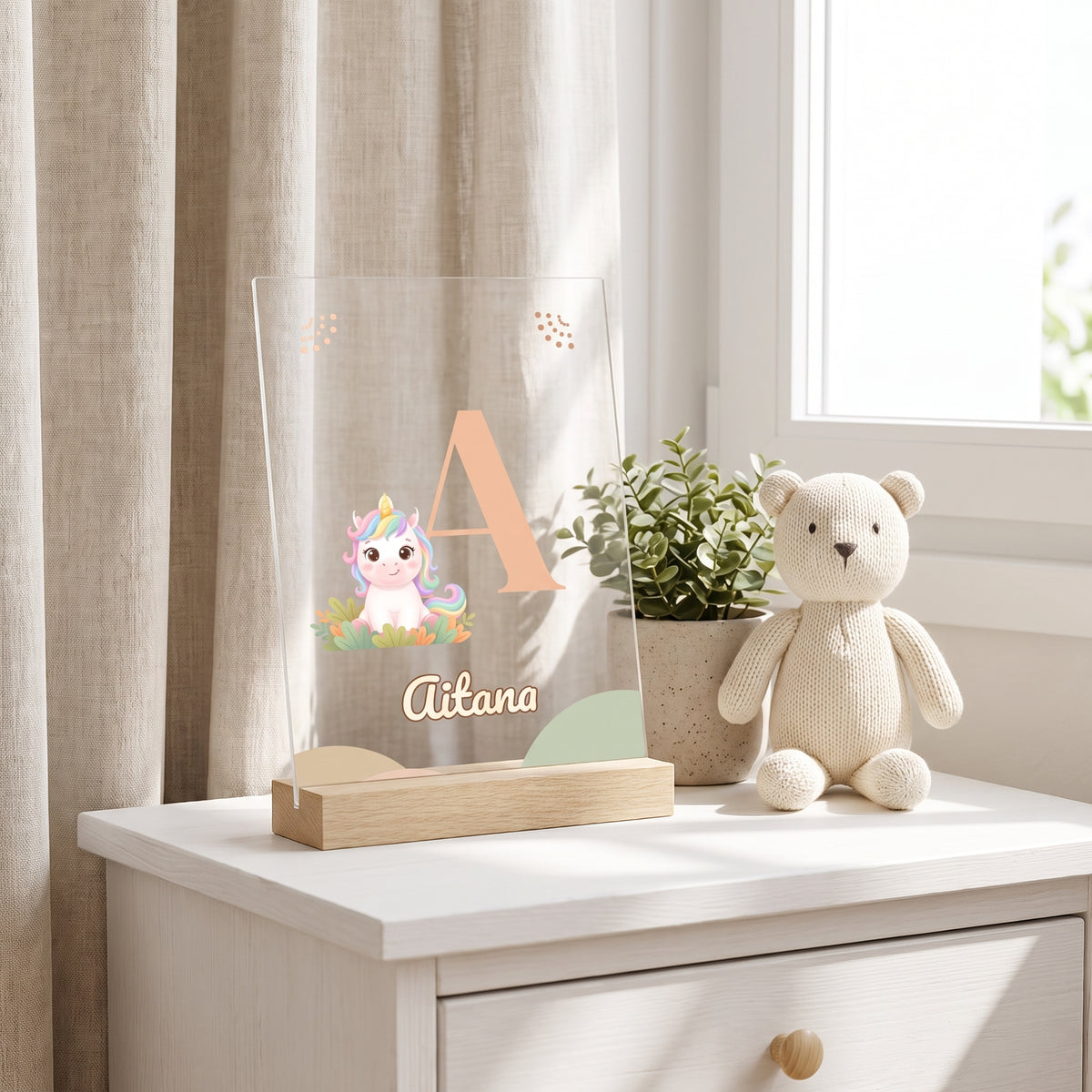 Lámpara infantil personalizada con inicial y nombre con la A, un unicornio y el nombre Aitana, sobre una cómoda en un dormitorio infantil
