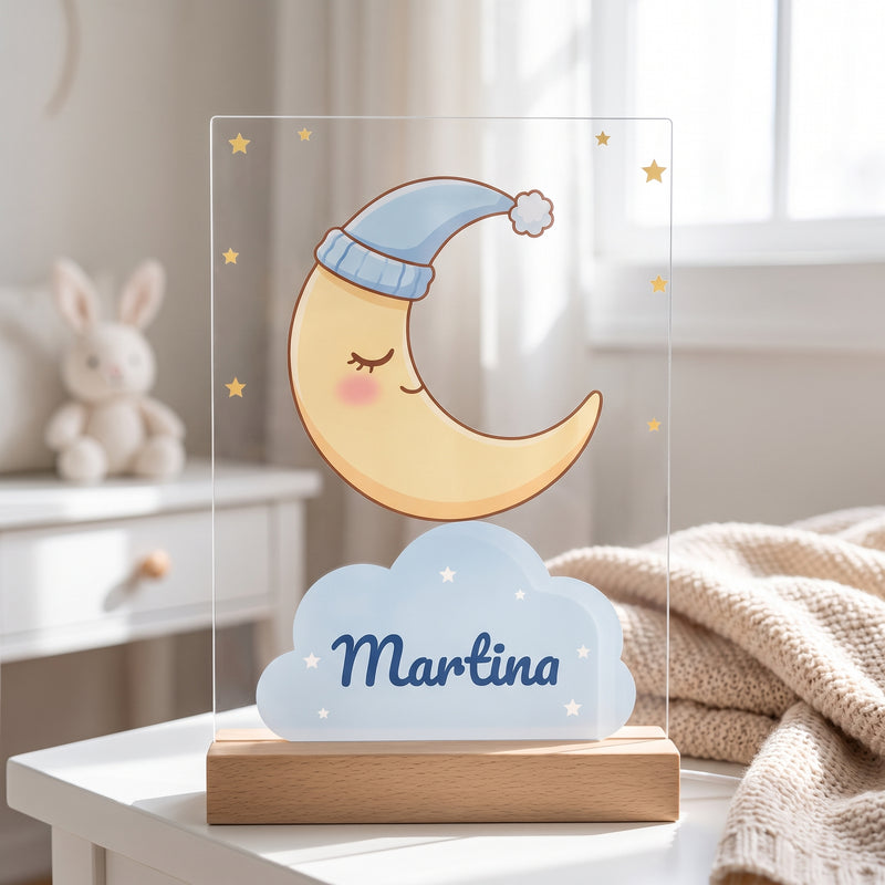 Lámpara quitamiedos personalizada con luna dormida con gorrito y el nombre Martina en una nube, sobre base de madera