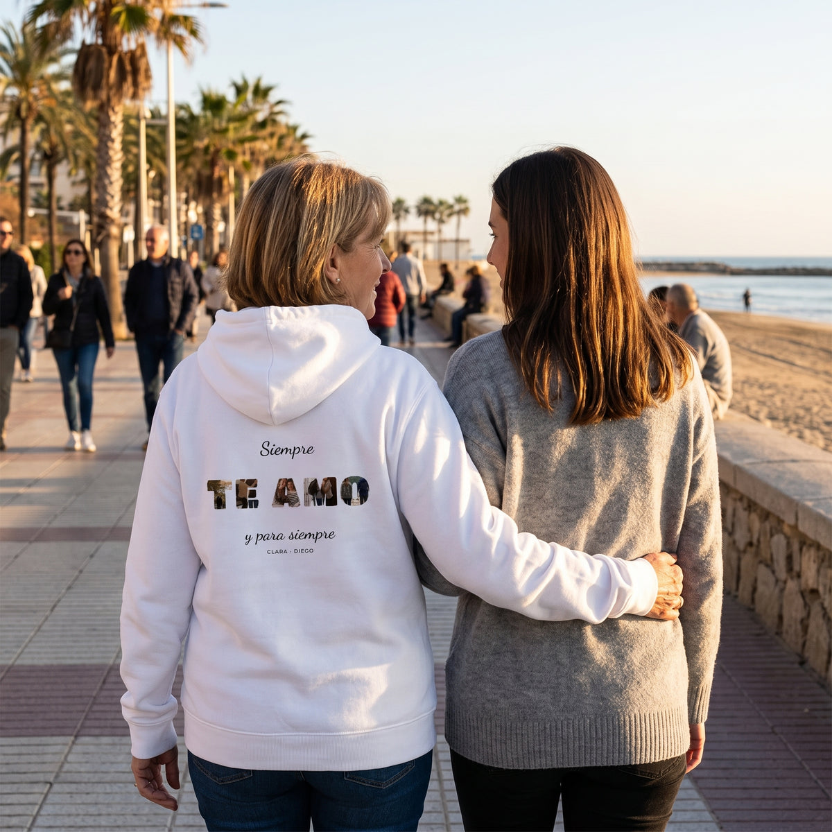Paseo al atardecer con la sudadera con capucha blanca personalizada con la palabra TE AMO con las letras rellenas de fotos estampado en la espalda