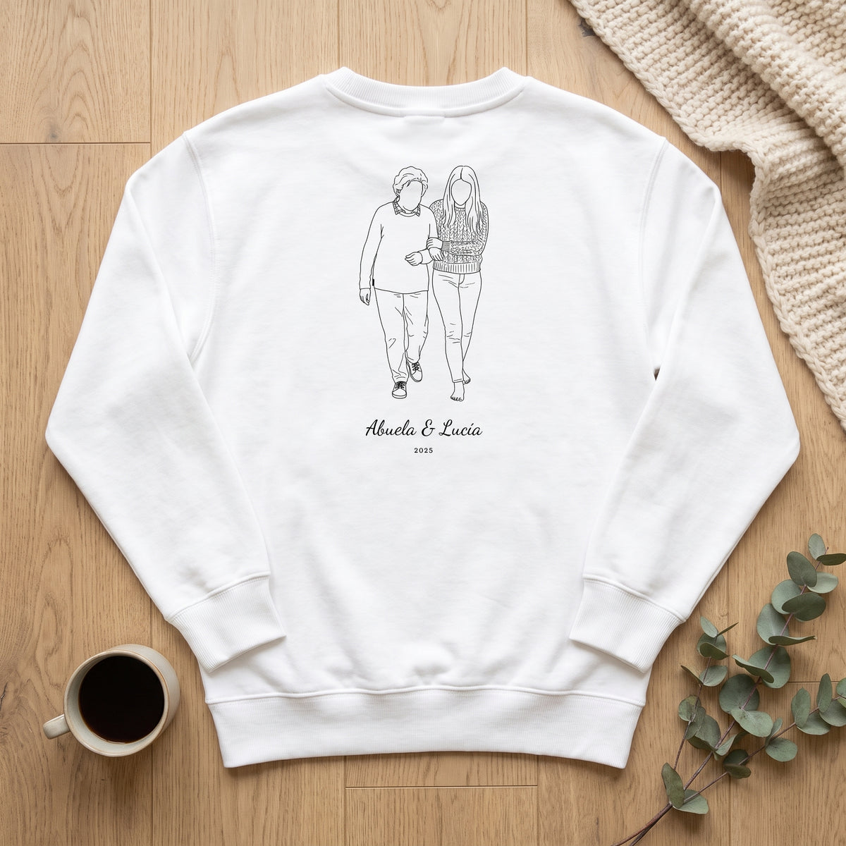 Sudadera blanca personalizada con el dibujo lineal de una abuela y su nieta y «Abuela & Lucía», vista de plano