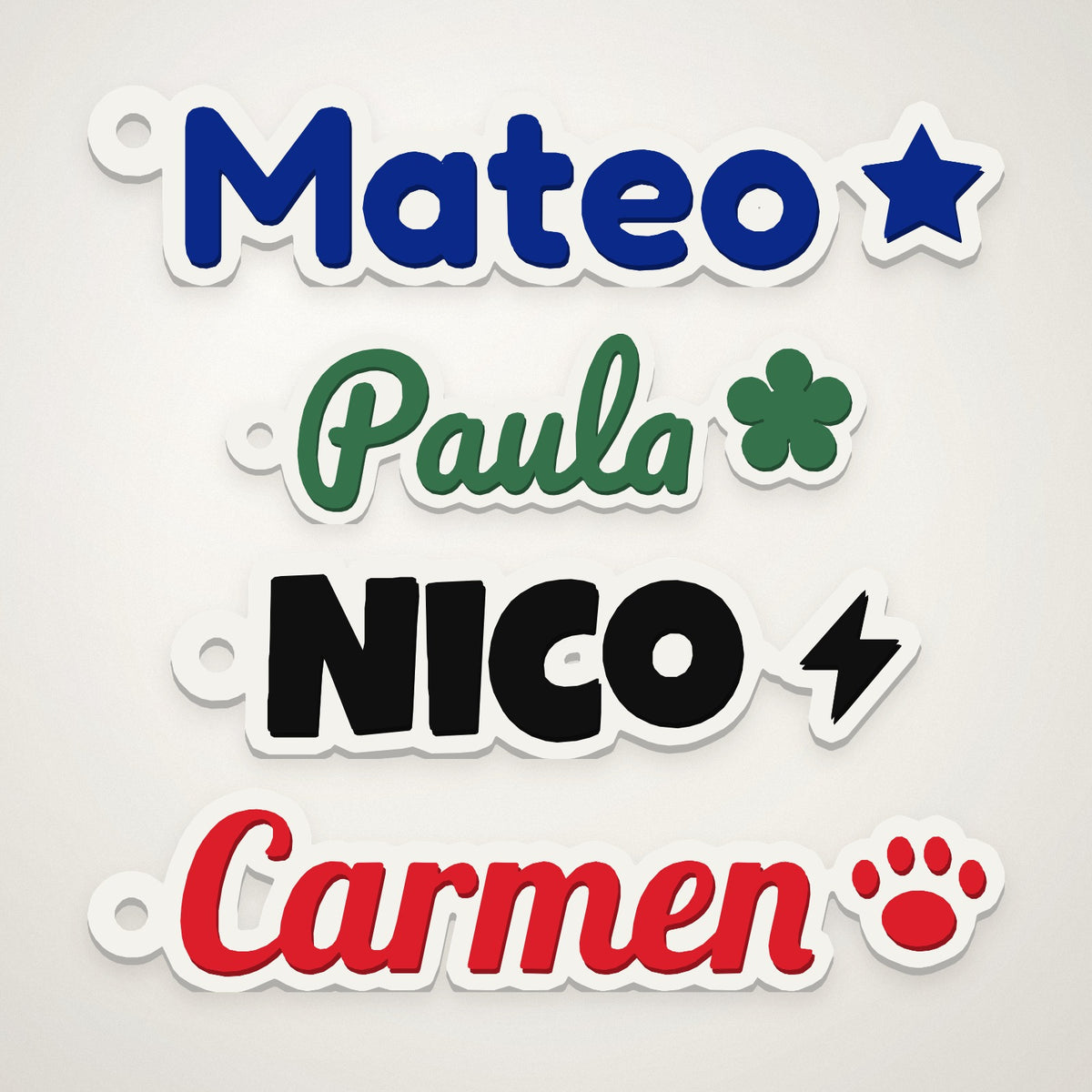 Cuatro llaveros de nombre impresos en 3D con letras y colores distintos: Mateo, Paula, Nico y Carmen