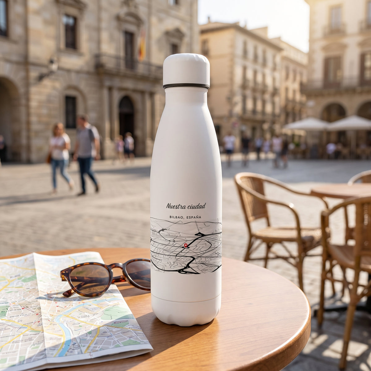 La botella con el mapa de Bilbao dando la vuelta, en una mesa de café