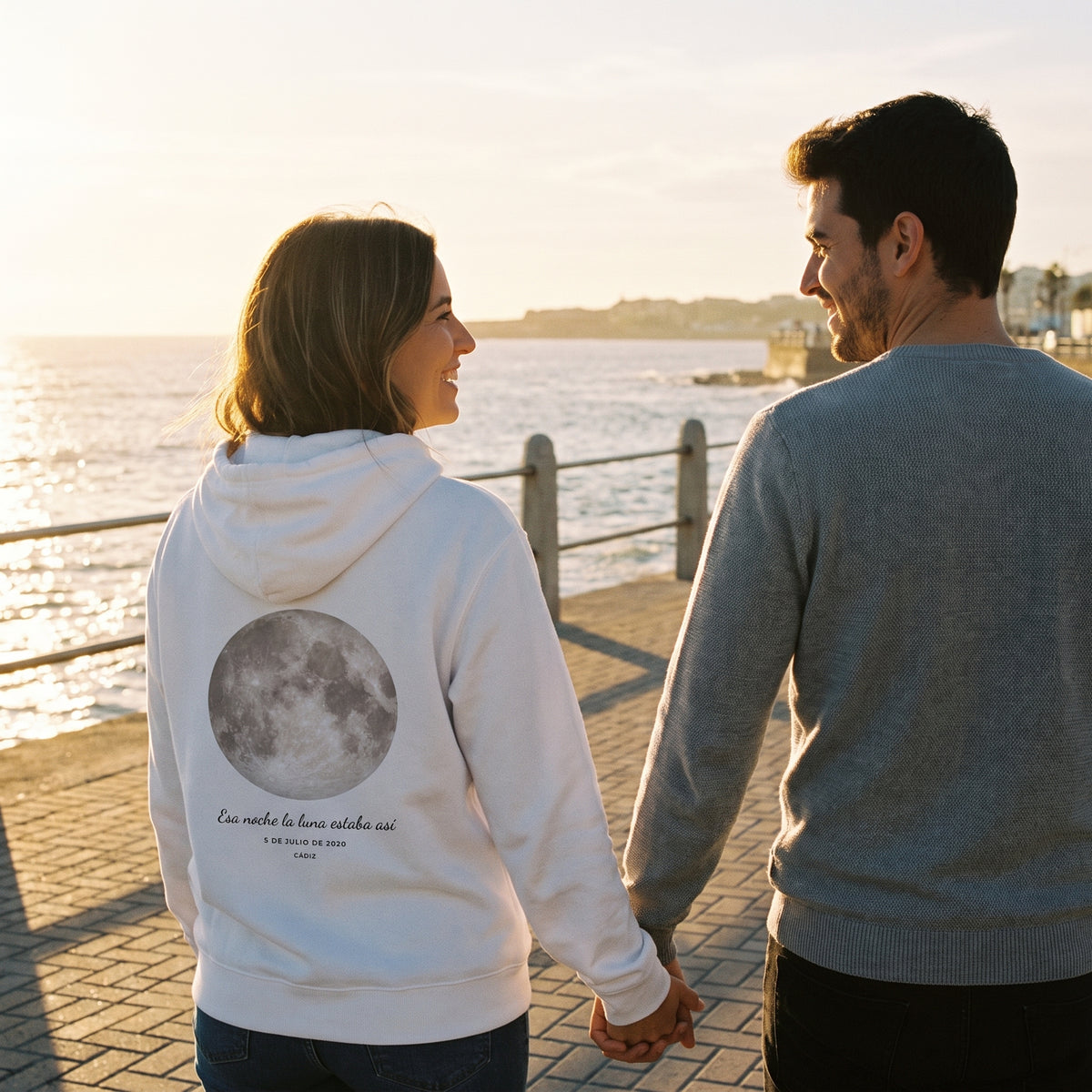 Paseo al atardecer con la sudadera con capucha blanca personalizada con la luna de la noche elegida y «Esa noche la luna estaba así» estampado en la espalda