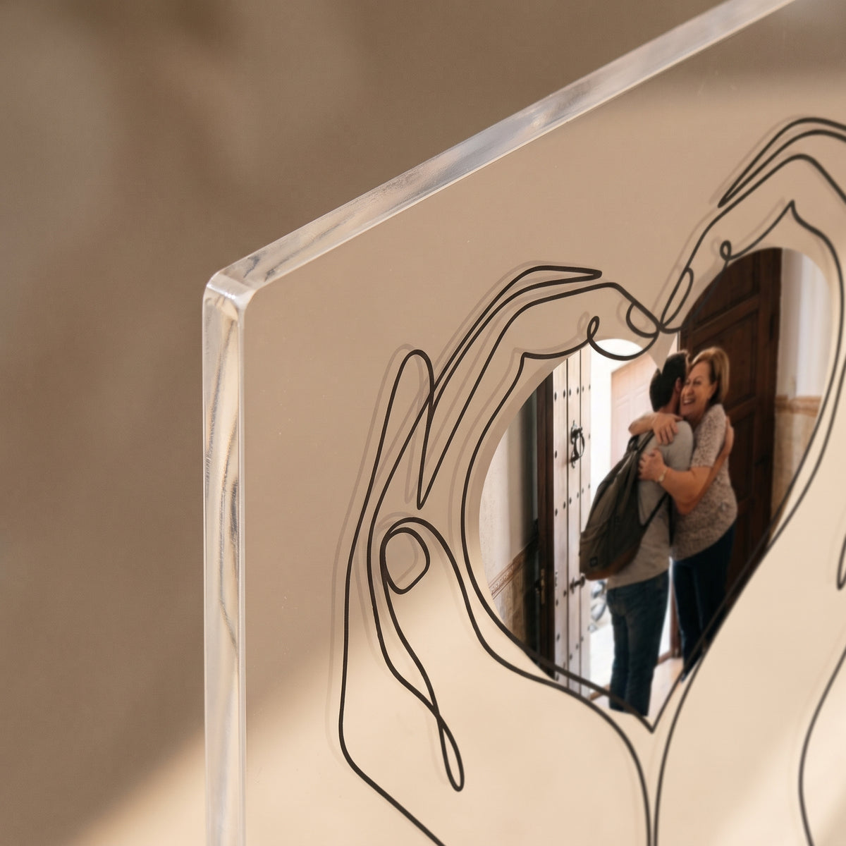 Detalle del canto pulido y de la impresión UV de la placa de metacrilato personalizada con unas manos que sostienen la foto