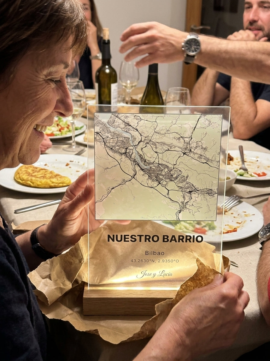 Abriendo el regalo de la placa de metacrilato personalizada con el mapa de vuestro lugar en corazón en una comida familiar
