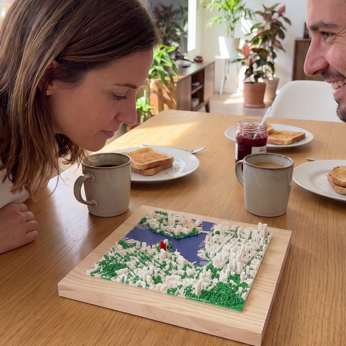 Una pareja mira en el desayuno el mapa 3D de su ciudad, apoyado en la mesa